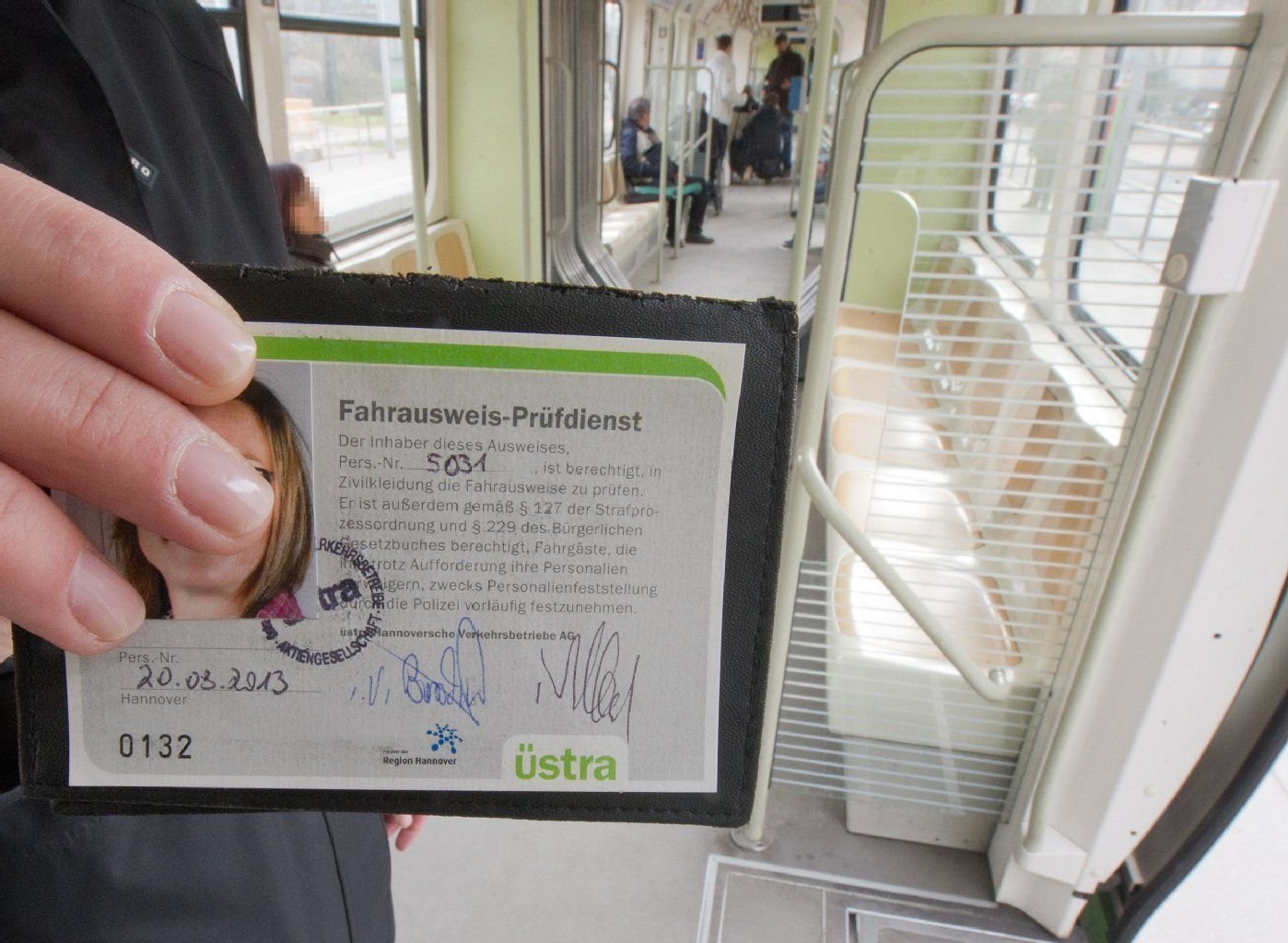 Eine Mitarbeiterin der Verkehrsbetriebe in Hannover zeigt bei einer Fahrscheinkontrolle ihren Dienstausweis.