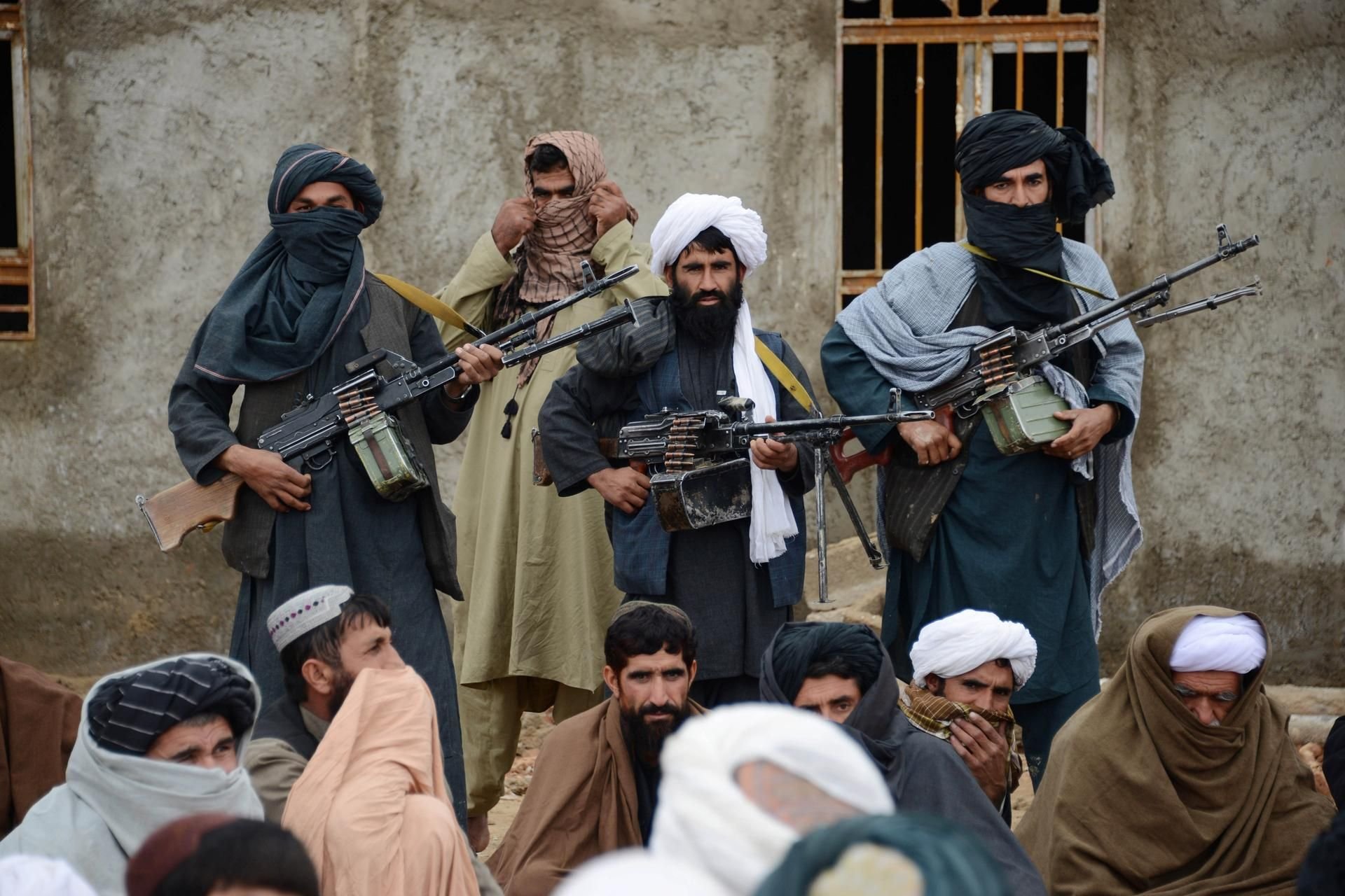 Ein paar bewaffnete Taliban-Kämpfer bewachen eine Meute. (Symbolbild)