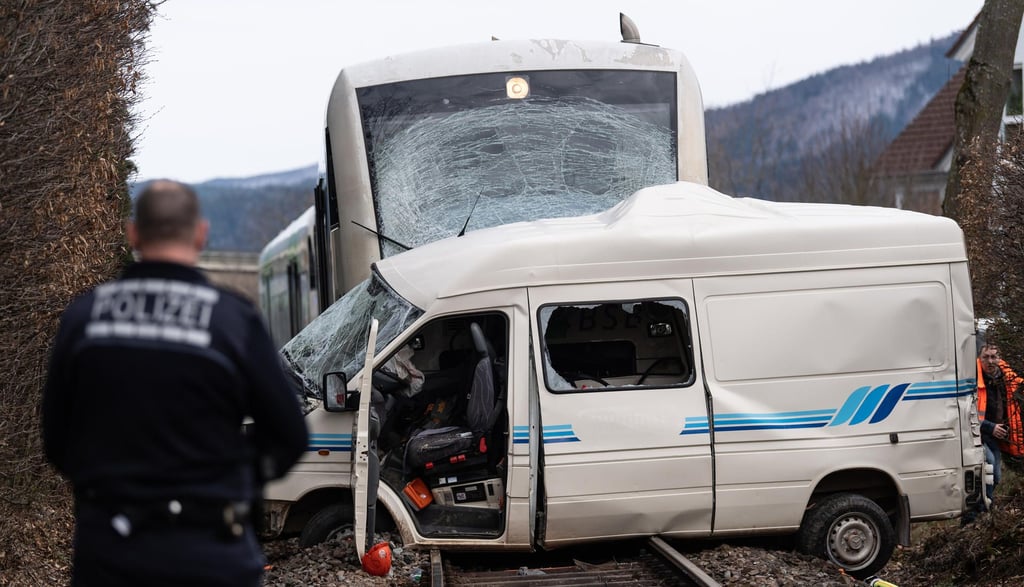 Ein stark beschädigter Transporter steht vor einem Zug auf den Bahngleisen. Nach Polizeiangaben hatte der Transporterfahrer den Zug übersehen. Der Fahrer wurde bei dem Unfall tödlich verletzt.
