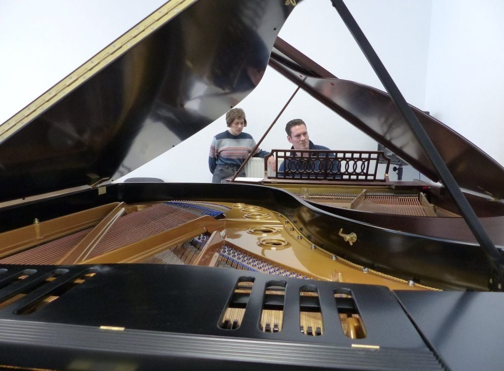 Das Innenleben des restaurierten Blüthner-Flügels. Bastian Thomas Kohl und Anna Franziska Rothe üben an einem weiteren Instrument.