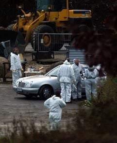 Mitarbeiter des polizeilichen Erkennungsdienstes stehen am Donnerstag (30.10.2003) an einem silberfarbenen Mercedes in einer Kompostierungsanlage im ostwestfälischen Bad Salzuflen. (Foto: dpa)