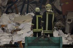 Feuerwehrleute suchen nach dem Einsturz eines Hochregals am Mittwoch in einer Lagerhalle eines Papiergroßhandels im Gewerbegebiet Queis nach einem Verschütteten. (Foto: ddp)