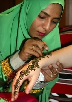 Samiya Al Balushi aus dem Oman bemalt die Hand einer Frau mit Henna-Mustern. Der Hautschmuck kann schwere gesundheitliche Schäden verursachen, warnt der Bund für Umwelt und Naturschutz Deutschland (BUND) in Berlin. (Foto: dpa)