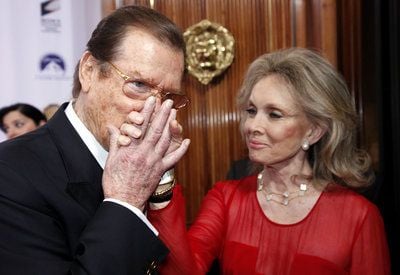 Der britische Schauspieler Roger Moore und seine Frau Kristina Tholstrup posieren im Hotel Bayerischer Hof in München im Rahmen der Verleihung des Deutschen Entertainment-Preises Diva auf dem Roten Teppich. (FOTO: DPA)