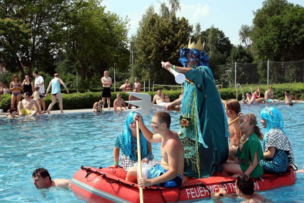 Neptun, der Herrscher über die Meere, alias Hagen Sippel, entert das Sommerbad in Theißen. Unterstützung erhält er dabei von der Feuerwehr, deren rotes Schlauchboot er zur Anreise nutzt.