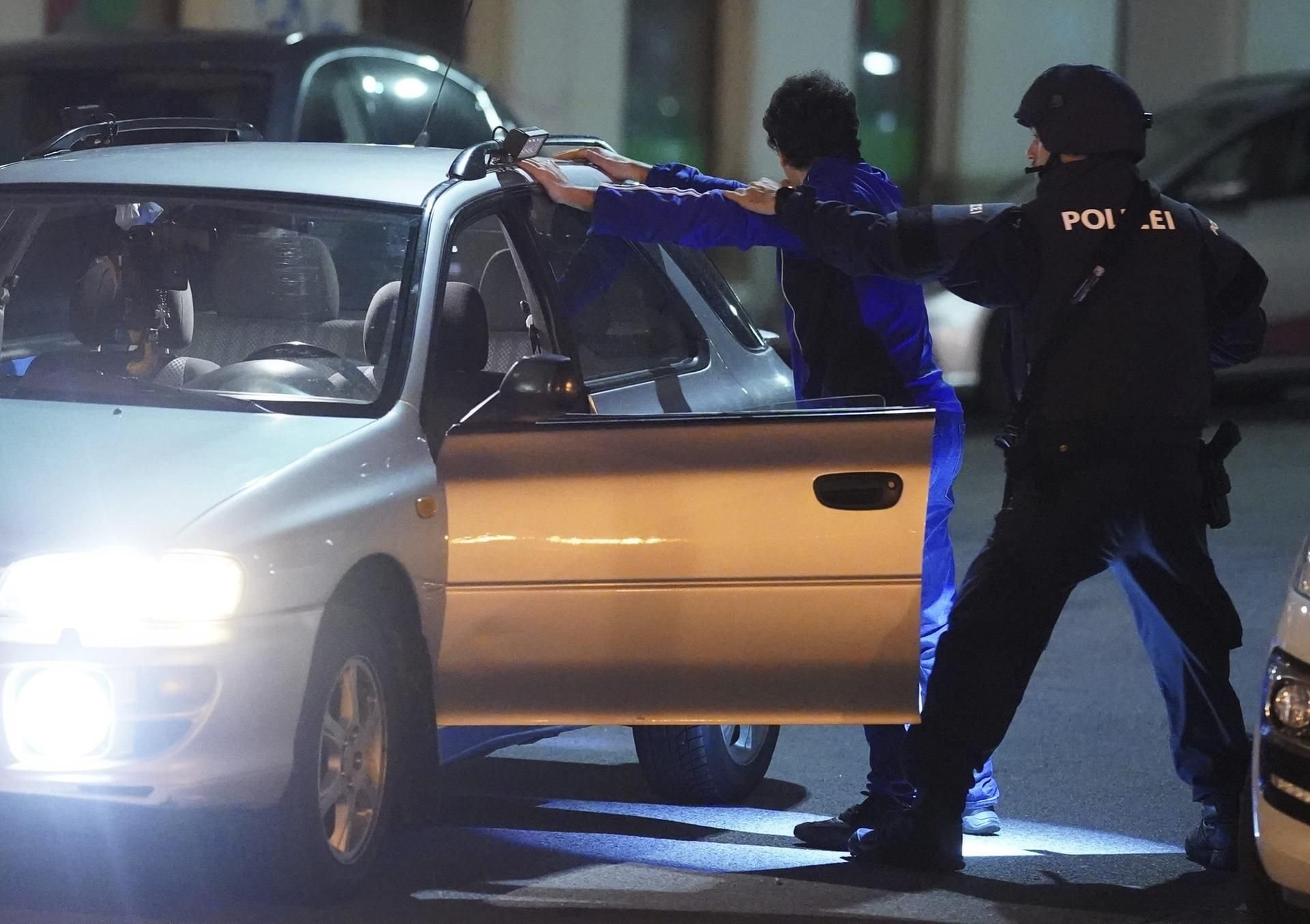 Polizisten kontrollieren eine Person nach dem Anschlag in Wien.