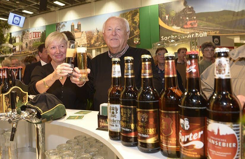 Gäste stoßen mit Bier am Stand der Landsberger Brauerei an.
