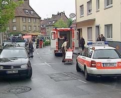 Notarztwagen und Polizeikräfte vor einem Haus in Witten, in dem bei einem Familiendrama ein 58-jähriger Vater am 14. Mai 2005 eine seiner drei Töchter erstochen und die beiden anderen durch Messerstiche schwer verletzt hat. (Foto: dpa)