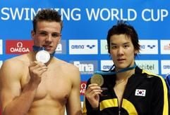 Der Südkoreaner Tae-Hwan Park (r.) und der Deutsche Paul Biedermann zeigen am 17. November 2007 in Berlin beim Schwimm-Weltcup nach dem Finale über 400 Meter Freistil ihre Medaillen. Biedermann belegte in neuer deutscher Rekordzeit den zweiten Platz hinter Park. (Foto: dpa)