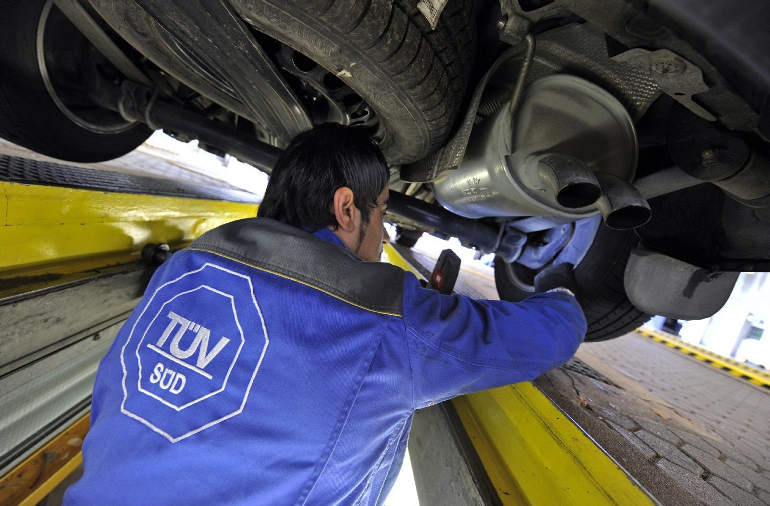 Ein Mitarbeiter des TÜV bei einer Kontrolluntersauchung