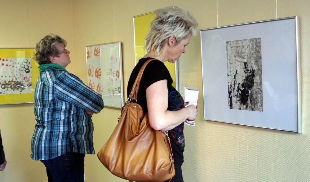 Neugierige Betrachter bei der Eröffnung der Bilderschau von Kindern mit Autismus in der Nordschule