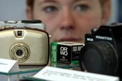 Eine Besucherin betrachtet am 15.08.2003 in der Ausstellung "Schon vergessen? Konsumgüter made in GDR" im Städtischen Museum "Sprucker Mühle" in der südbrandenburgischen Stadt Guben Fotoapparate vom Typ Penti und Praktika sowie ORWO-Filme aus DDR-Produktion. (Foto: dpa)