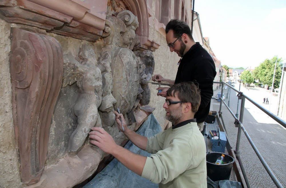 Steffen Marko (vorn) und sein Kollege Martin Fliedner konservieren das Wappenrelief am Amtsgericht.