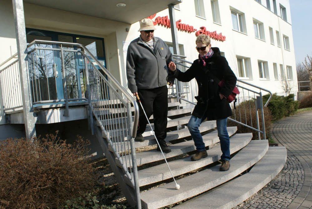 Ekatarina Kolitscher begleitet Matthias Weise im Alltag, hier meistern sie die Stufen von der Apotheke.