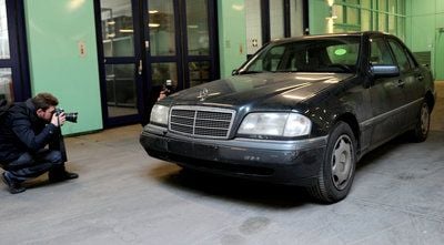 Ein Journalist fotografiert bei der Berliner Polizei den Fluchtwagen der Berliner Poker-Räuber. (FOTO: DPA)