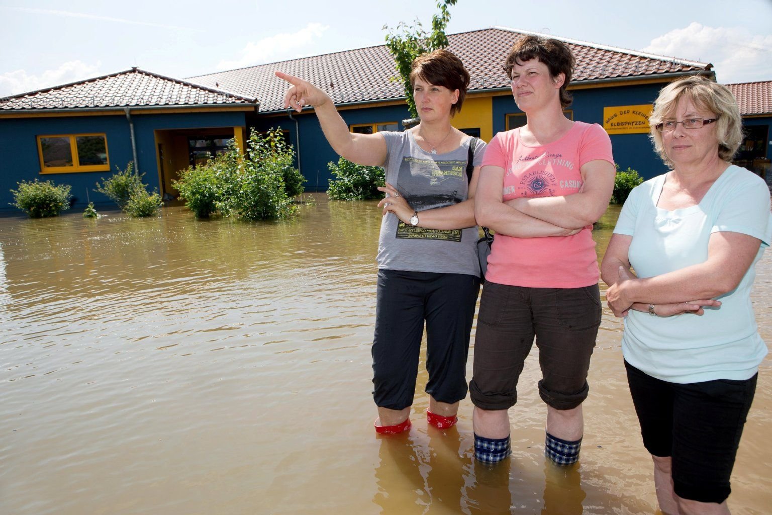 Hochwasser an der Elbe in Elster. Der Kindergarten in Elster steht knietief unter Elbe-Wasser. Leiterin Janet Leder, deren Mitarbeiterin Antje Böhme und Servicekraft Manuela Müller (v.l.) begutachteten das Drama.