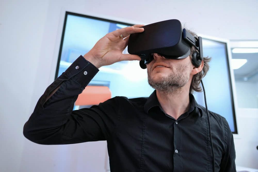 Karsten Schwarz präsentiert eine VR-Brille.