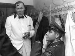 Der US-amerikanische Rock´n Roll Sänger Elvis Presley (r.) besucht in Uniform seinen Kollegen Bill Haley in der Garderobe vor dem Auftaktkonzert zu seiner Tournee in Frankfurt am Main (Archivbild vom 23.10.1958). (Foto: dpa)