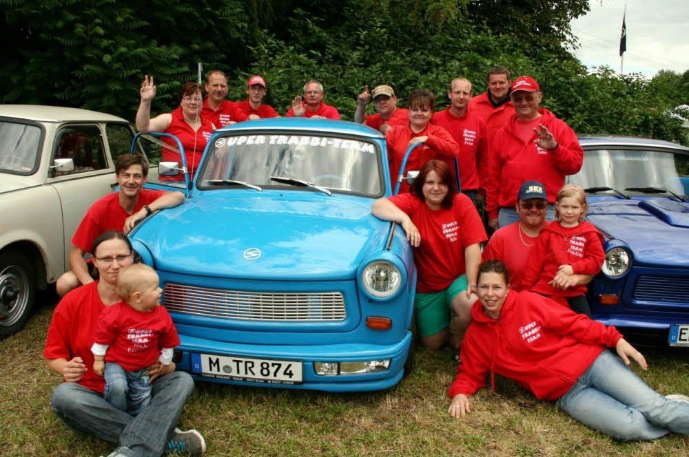Die Clubmitglieder des „Super-Trabbi-Teams“ Grabo postieren sie sich am himmelblauen Trabant von Conny Schmidt aus München.
