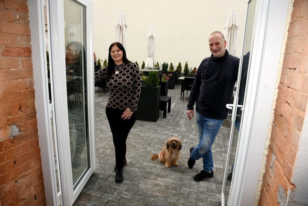 Haben die Corona-Zwangspause im November genutzt: Für Maria Theuring, die sich um den Service im „Filou“ kümmert, sind die Wege zur Terrasse jetzt dank Durchbruch kürzer. Koch Thomas Ledabyll freut sich über eine neue Decke in der Küche. Zum kleinen Team gehört auch Vierbeiner Max.
