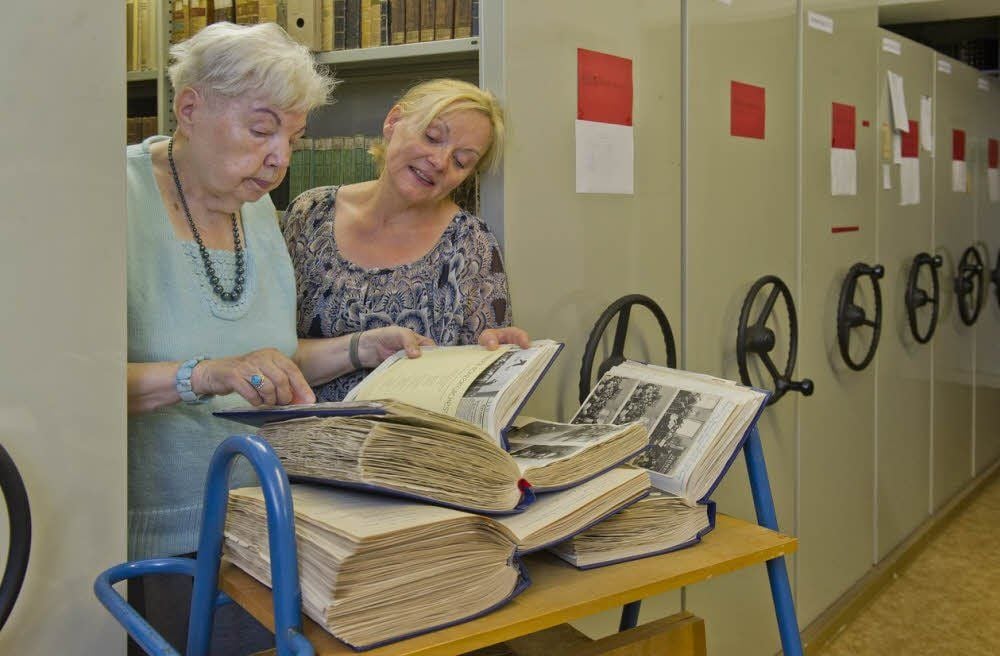Waltraud Wyrwal (l.) überreichte eine mehrere hundert Seiten dicke Chronik über das Staatliche Orchester Quedlinburg an Bibliothekarin Regina Schade.