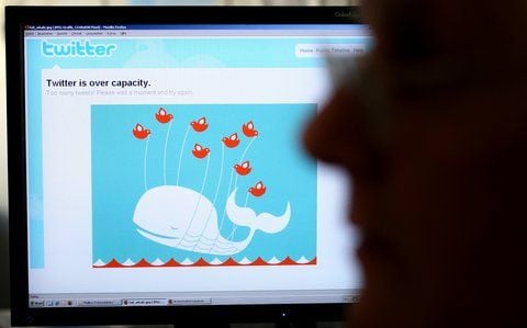 Ein Mann sitzt vor einem Computermonitor, auf dem ein Screenshot mit einem Hinweis auf Überlastung bei Twitter zu sehen ist. (FOTO: DPA)