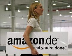 Eine Frau geht am Donnerstag (17.08.2006) mit dem Firmenlogo des Internet-Einzelhändlers Amazon durch die Versandhalle des Unternehmens in Leipzig. (Foto: dpa)