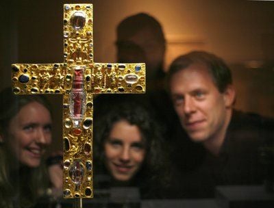 Das «Borghorster Stiftskreuz» wird in der neuen Ausstellung: «Spektakel der Macht» im Kulturhistorischen Museum in Magdeburg von einer Besuchergruppe betrachtet. Das vergoldete Vortragekreuz stammt aus dem Jahr 1050. (Foto: dpa)