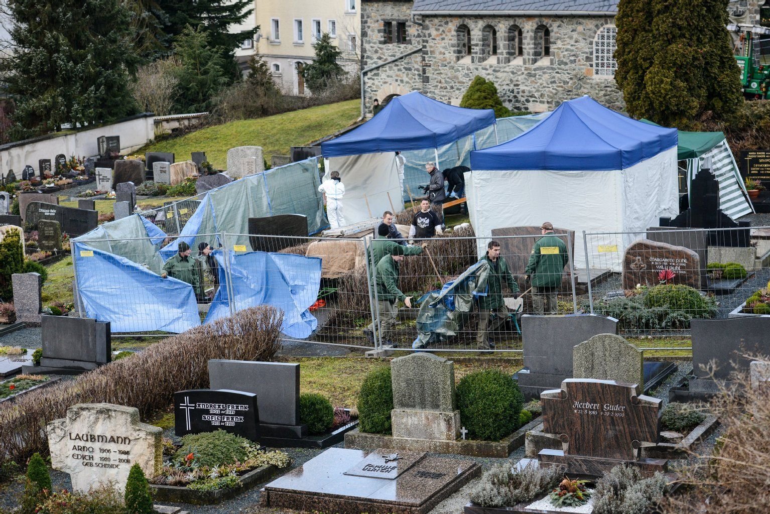 Beamte der Spurensicherung bauen am 08.01.2014 auf dem Friedhof in Lichtenberg (Bayern) nach der Suche nach der Leiche des Mädchens Peggy ihre Zelte ab.