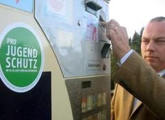 Mit einer Geldkarte demonstriert Tabakwaren-Händler Hermann Ecker die Funktion der neuen Zigarettenautomaten. (Foto: dpa)