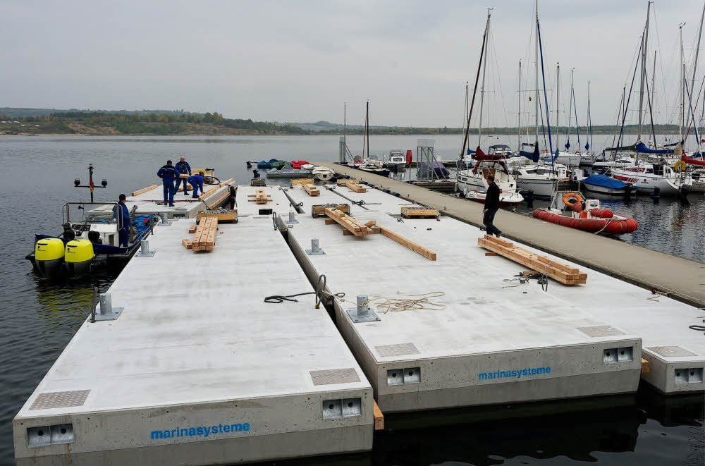 Die angelieferten Schwimmstege warten an der Marina Mücheln auf ihren Transport zum Strand-Ufer.