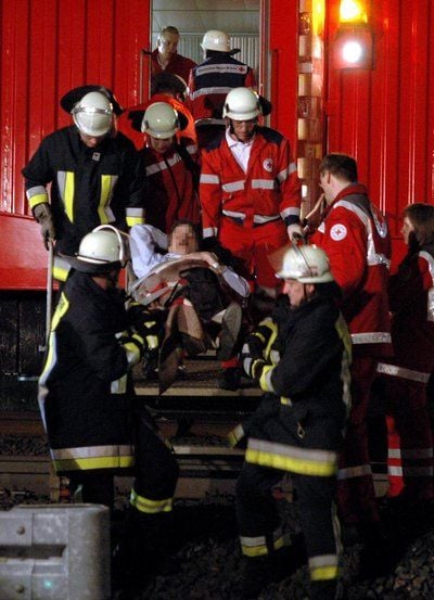 Feuerwehrleute und Sanitäter tragen am 26.04.08 einen Verletzten aus einem im Landrückentunnel zwischen Fulda und Würzburg entgleisten ICE. (FOTO: DDP)