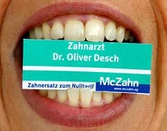 Eine Zahnarzthelferin hat am Dienstag (26.09.2006) in Krefeld ein Schilchen des umstrittenen Dental-Discounters McZahn zwischen den Zähnen. (Foto: dpa)