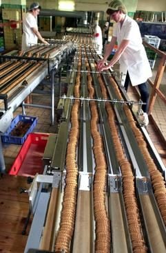 An der Verpackungslinie in der Wikana Keks und Nahrungsmittel GmbH in Wittenberg kontrollieren Mitarbeiterinnnen die Qualität der Produkte.