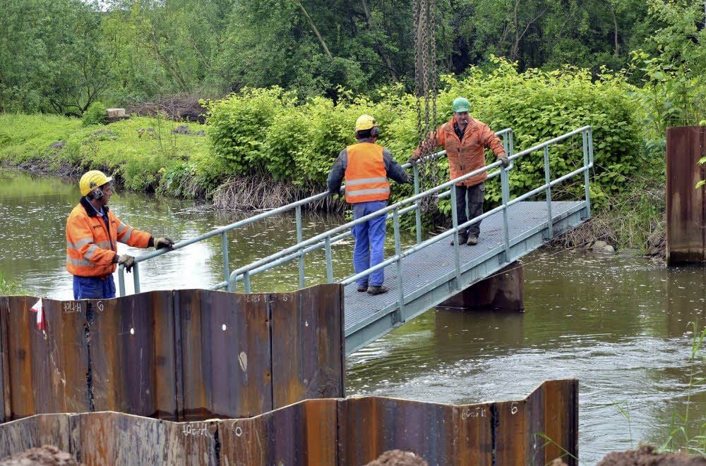 Arbeiter der Firma Krause und Co. bauen eine Behelfsbrücke ein.