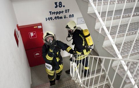 Zwei Feuerwehrleute laufen in voller Schutzausrüstung durch das Treppenhaus des Park Inn Hotels in Berlin zum Ziel auf der Aussichtsplattform. (FOTO: DPA)