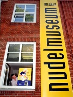 In der Teigwaren Riesa GmbH zeigt der Mitarbeiter Stefan Kuhl am Fenster des neuen Nudelmuseums ein Werbeschild des Betriebes von 1960 (Archivbild vom 07.08.2003). (Foto: dpa)
