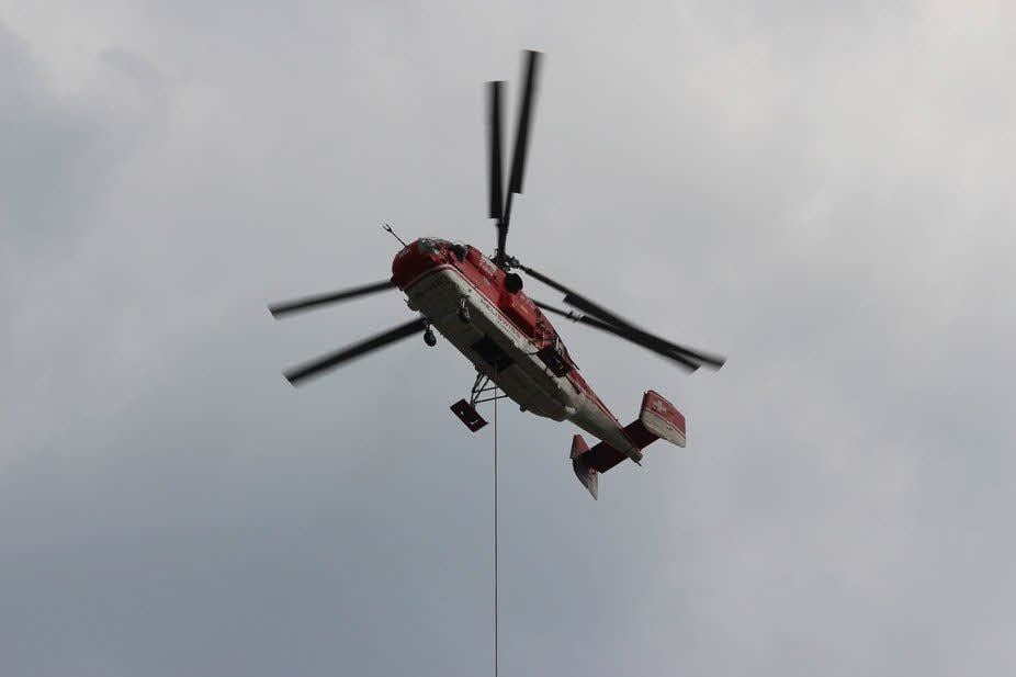 Der von der Bahn angemietete Hubschrauber bringt ein Vorseil von Mast zu Mast.