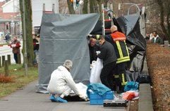 Bestatter tragen in Lübeck nach einem Mord an einer Frau den Leichnam aus dem Spurensicherungszelt. Die 36-Jährige wurde von ihrem Ex-Mann auf offener Straße mit einer Axt erschlagen, als sie mit ihrem Fahrrad auf dem Nachhauseweg war. (Foto: dpa)