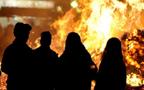 Menschen stehen vor einem Osterfeuer. (SYMBOLFOTO: DPA)