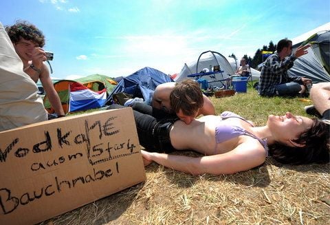 Bart aus Holland schluerft am Samstag (04.06.11) in Nuerburg am Nuerburgring auf einem Campingplatz beim Musikfestival Rock am Ring Wodka aus dem Bauchnabel von Susann aus Marburg. (FOTO: DAPD)