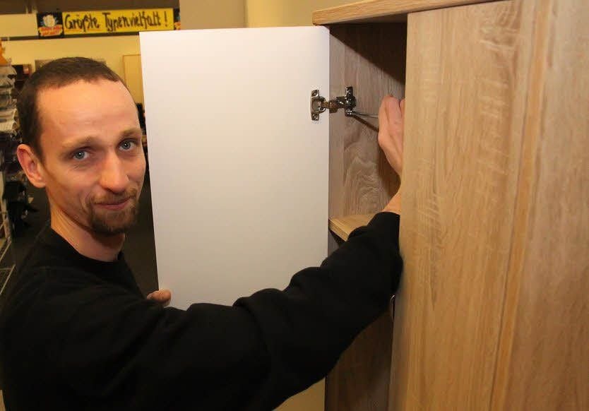 Thomas Albrecht montiert einen Schrank.