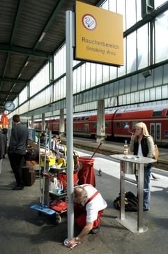 Ein junge Frau raucht in einer Raucherzone auf einem Bahnsteig im Hauptbahnhof von Stuttgart. (Foto: dpa)