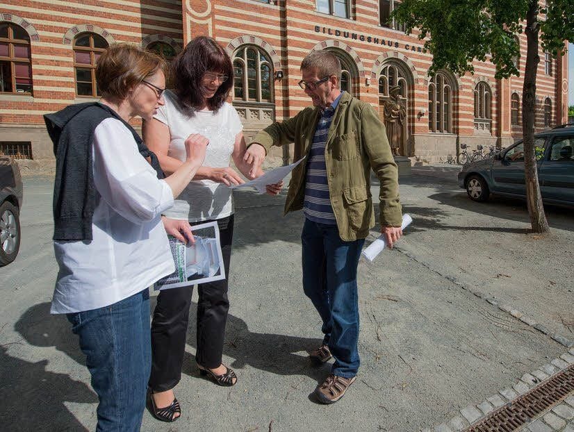 Antje (links) und Matthias Steinecker vergleichen zusammen mit Gerlinde Schöpp die Pläne für die Gestaltung des Hofes mit den Gegebenheiten am Bildungshaus.