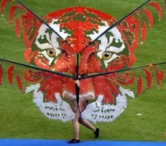 Eine Frau mit einer überdimensionalen Tigermaske geht am Mittwochabend (13.07.2005) bei der Generalprobe zur Eröffnungsfeier über den Rasen der MSV Arena in Duisburg. (Foto: dpa)