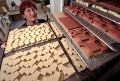 Spielzeugsteine, die aus den Naturmaterialien Kreide, Quarzsand und Leinölfirnis gepresst sind, entnimmt am Dienstag (20.09.2005) die Mitarbeiterin Renate Bohun in der Anker Steinbaukasten GmbH im ostthüringischen Rudolstadt aus einem Trockner. (Foto: dpa)