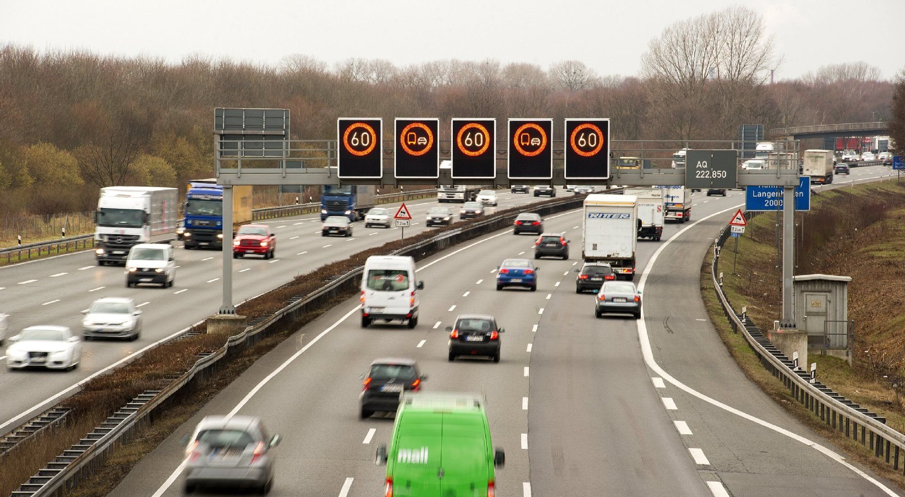 Autos fahren auf der A2 nördlich von Hannover unter einer Schilderbrücke entlang.