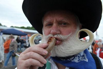 Ein Würstchen frisch vom Grill probiert Karlheinz Stengel vom Team «Zunftgriller» bei den Deutschen Grillmeisterschaften in Osterholz-Scharmbeck. (FOTO: DPA)