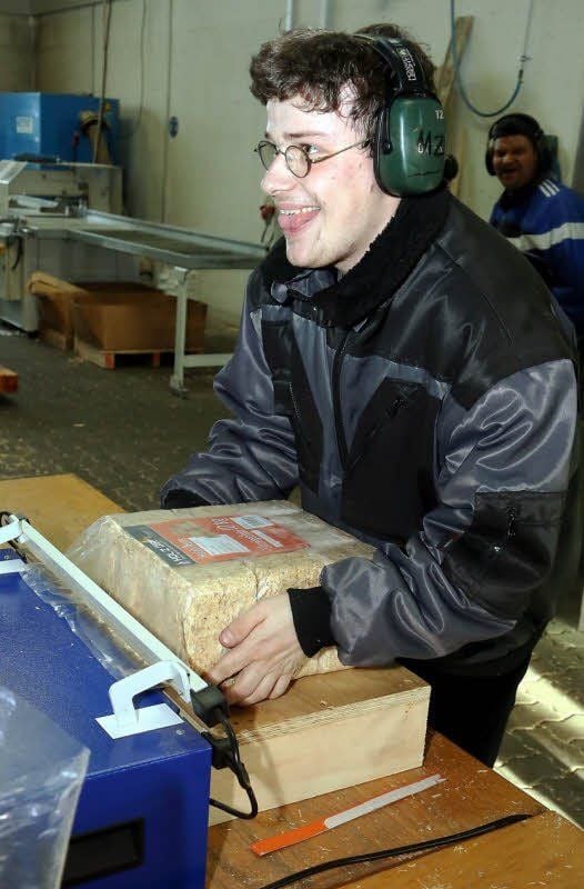 Markus Zorn, auf dem Diest-Hof in Seyda zu Hause, verschweißt hier am Schrumpftunnel Zehn-Kilo-Pakete mit Holzbriketts. Geschredderte Altpaletten bilden als Späne das Ausgangsmaterial fürs Pressen der Holzbriketts.
