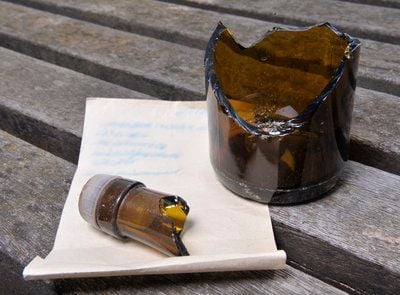 Eine zerbrochene Flasche und ein vergilbter Brief einer Flaschenpost liegen in Göttingen auf einer Holzbank. (FOTO: DDP)